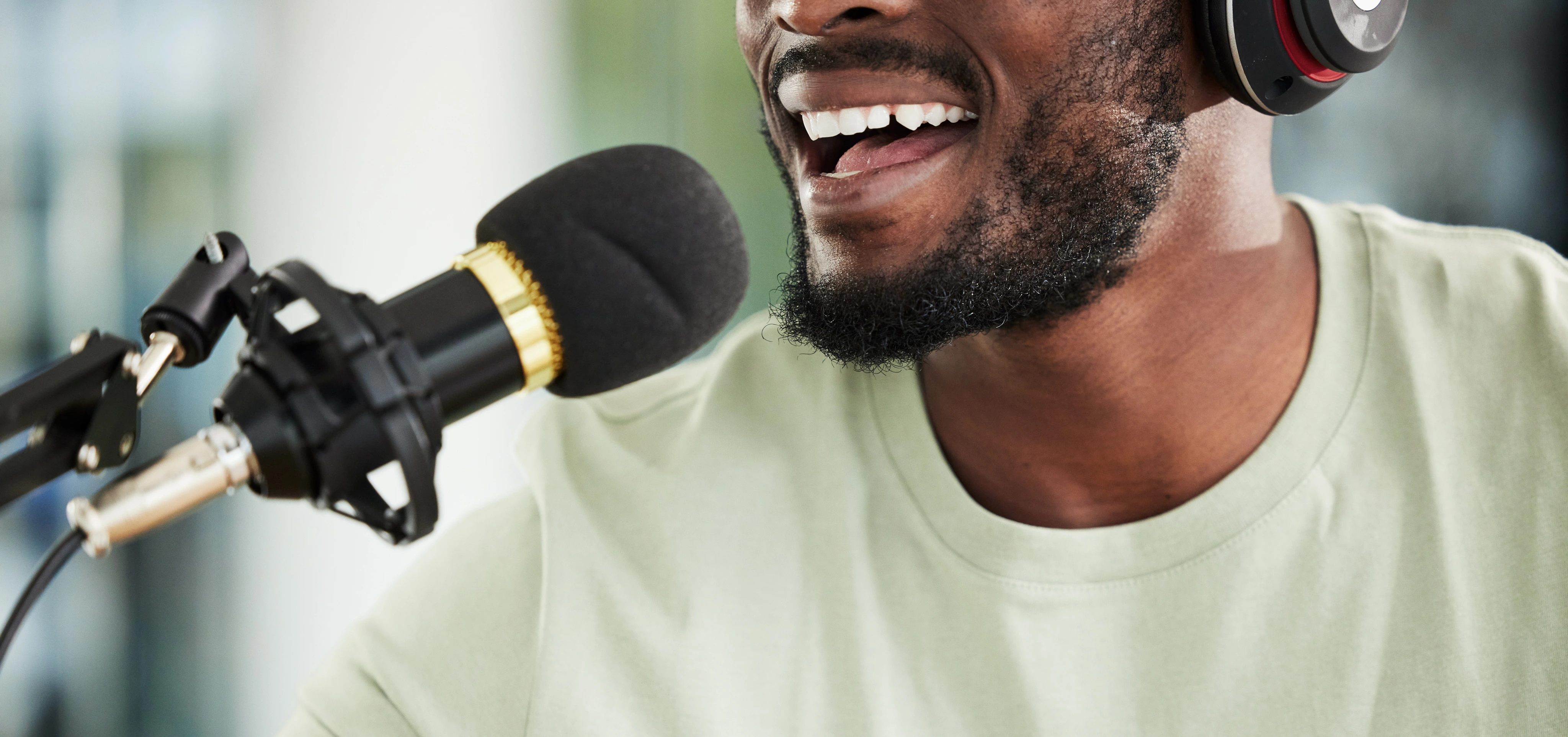 A man speaking to a microphone using AI Voice Cleaning technology to improve his recording